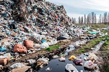 A mountain of plastic as tall as a large tree, on land